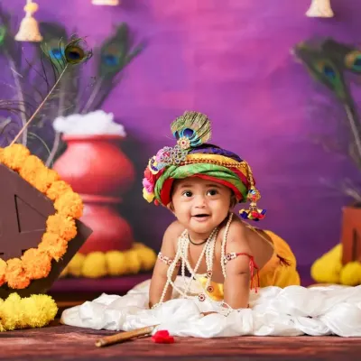 Our little Krishna crawling in a vibrant setup for Janmashtami, complete with marigolds, peacock feathers, and a pot of butter.