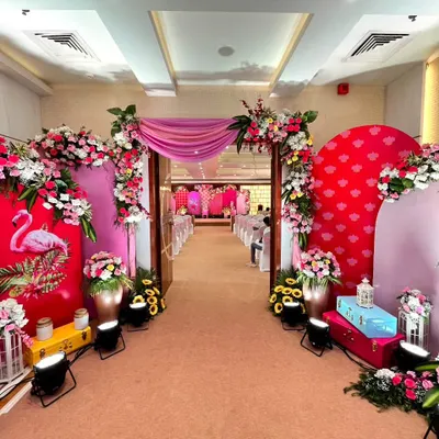 A full view of our flamingo-themed Haldi entrance. The pink and red floral arrangements, combined with whimsical flamingo panels and colorful trunks, create a fun, modern, and cohesive look that welcomes guests into a vibrant space.