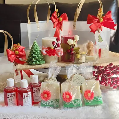 A full Christmas collection display, featuring tree and pillar candles, angel candles, handmade soaps, and body wash, all ready to be packed into festive gift bags.