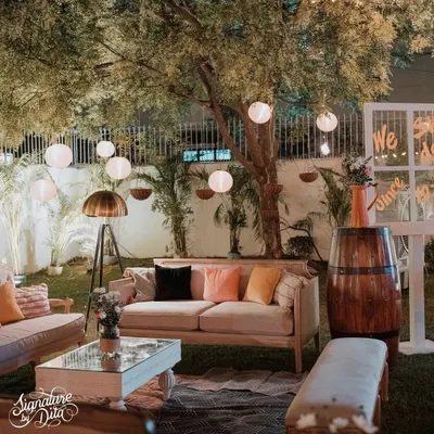 For this 50th anniversary, I created a cozy lounge area under the trees. The setup featured comfortable sofas with colorful cushions, a vintage floor lamp, and hanging paper lanterns for soft, ambient lighting.