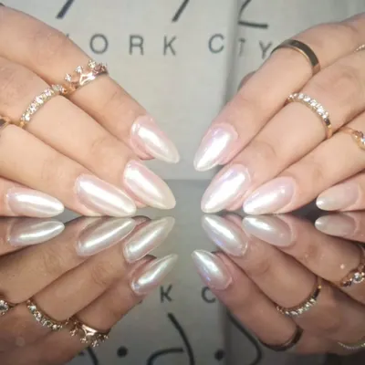 A stunning set of long, stiletto nails with a pearlescent white finish that gives off a beautiful, ethereal glow.