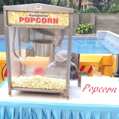 Our popcorn machine rental is perfect for any event, set up here by a pool. I provide the machine and an operator to ensure a constant supply of fresh popcorn for your guests.