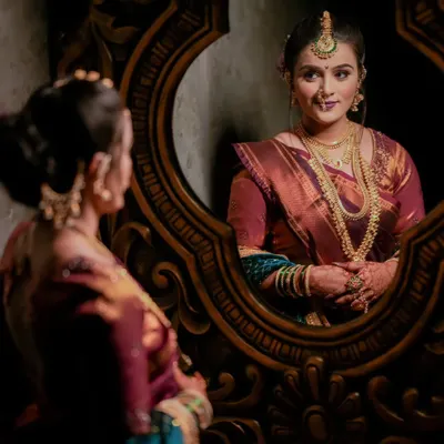A creative bridal portrait using a mirror to capture the bride's reflection. This adds depth and an artistic touch to the getting-ready photos.
