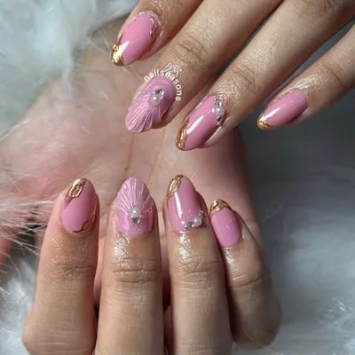 A beautiful design featuring a soft pink base with gold chrome details and a stunning 3D seashell accent nail, adorned with pearls and rhinestones.