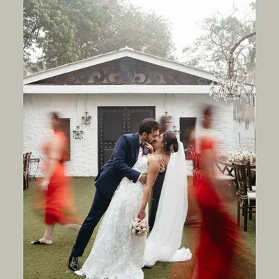 A creative motion-blur shot capturing the couple's kiss just after their first look. While the world rushes by in a blur of color, they are frozen in a perfect, still moment of love and anticipation before their wedding ceremony.