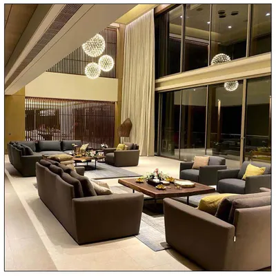 We transformed this living room in Aamby Valley into an oasis of comfort and style. The double-height ceiling, dramatic spherical chandeliers, and expansive glass walls create a space that is both grand and inviting.