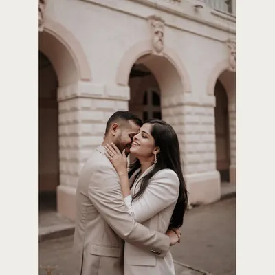 An intimate embrace against a classic urban architectural backdrop. This candid moment captures the tenderness and affection of the couple, creating a romantic and stylish city pre-wedding photo.