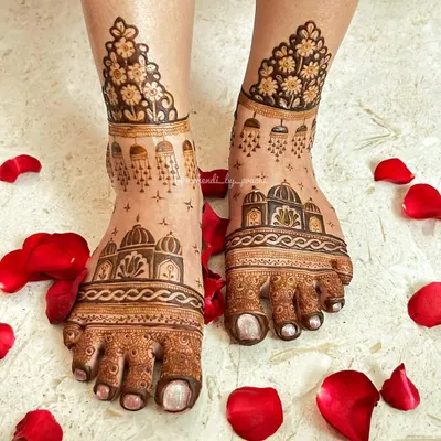 Bridal mehndi isn't just for hands. I love adorning feet with designs like this, featuring delicate architectural domes and floral patterns, beautifully framed with scattered rose petals for the perfect shot.