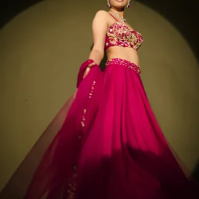 A classy and elegant shot of model Athulya Chandra for a fashion editorial. I created a sophisticated look with a sleek, side-parted hairstyle and glowing skin to complement the vibrant pink lehenga and diamond jewelry.