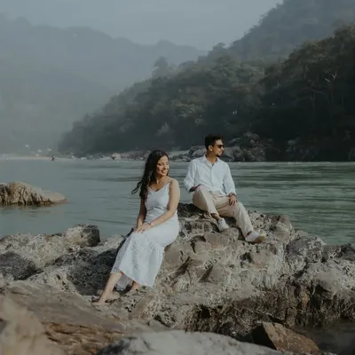 A serene couple portrait taken on the rocks by the Ganga river in Rishikesh. The majestic mountains and calm waters provide a breathtaking backdrop for this destination pre-wedding shoot.