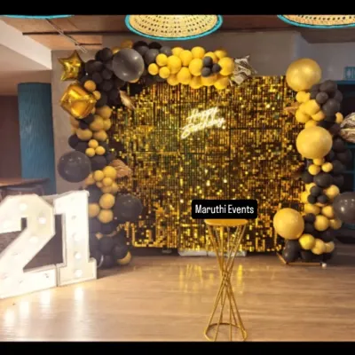 A glamorous 21st birthday setup. This party features a stunning gold sequin wall, a black and gold balloon arch, and giant light-up numbers for the perfect photo opportunity.