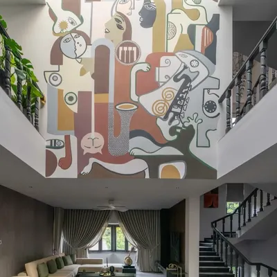 This double-height mural in a living room is a perfect example of how art can become the central architectural feature of a home. The abstract composition of faces and forms draws the eye upward, creating a sense of grandeur and narrative depth.