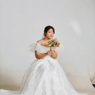 Our white organza ball gown is perfect for creating a dreamy, bridal-inspired look for your pre-wedding shoot. The ruffled off-the-shoulder sleeves add a touch of modern romance.