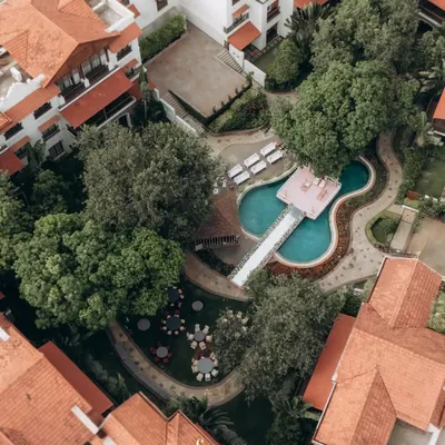 An aerial view of the stunning Rhythm Lonavala resort during Parth and Dhriti's wedding. This drone shot captures the beautiful layout of the venue, including the unique guitar-shaped pool.