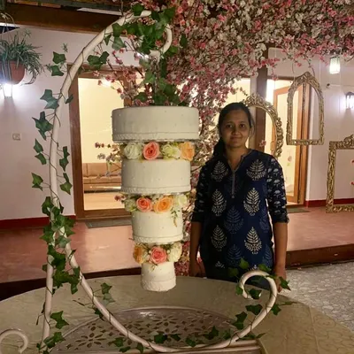 Standing proudly next to one of my suspended chandelier cakes. This four-tier creation, decorated with delicate peach and white florals, was assembled at the venue to create an unforgettable focal point for the event.