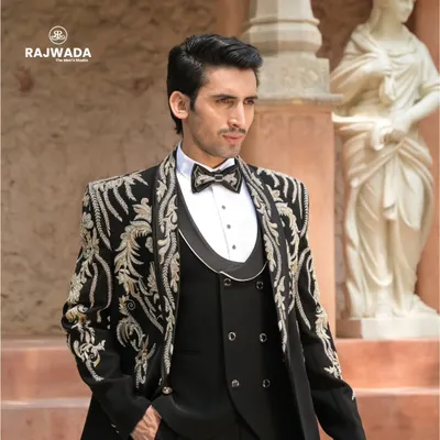 A detailed look at our black three-piece tuxedo with stunning gold and silver baroque embroidery. This is a signature piece from the Crown & Collar collection, designed for a groom's grand reception.