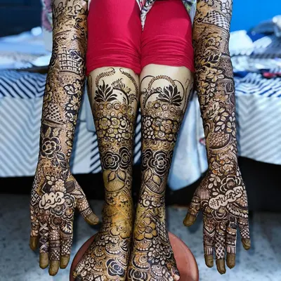 A full bridal look for a Nikah bride, with intricate floral designs covering her hands, arms, and feet for a stunning head-to-toe effect.