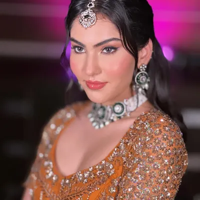 A bold and beautiful look featuring a sharp winged liner, contoured cheeks, and a glossy lip, paired with a rustic orange lehenga.