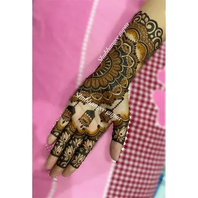 This is a great example of a "no mirror image" design. One hand features a large, intricate mandala, while the other has a simpler pattern with hanging jhumkas, creating a balanced yet unique look.