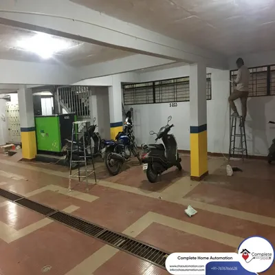 This wide shot shows our team at work in a parking garage of an apartment complex in Vidyaranyapura, installing a comprehensive CCTV network to secure the entire premises.