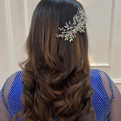 A beautiful hairstyle for a reception or cocktail party. These soft, bouncy curls are accented with a stunning crystal hairpiece, adding a touch of sparkle and glamour.