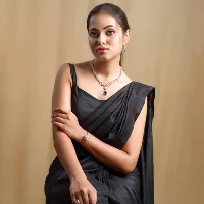 A close-up of the model in the black saree, showing the simple elegance of the outfit and the beautiful jewelry it's paired with.