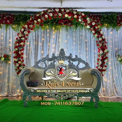 An elegant stage we designed for a 60th-anniversary celebration. The decor features a large floral ring against a backdrop of white curtains and fairy lights, creating a classic and romantic ambiance.