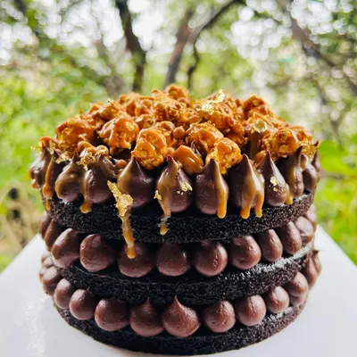 The perfect treat for a rainy day. This is my Chocolate and Salted Caramel naked cake, layered with rich chocolate ganache and topped with crunchy caramel popcorn and a touch of gold leaf.