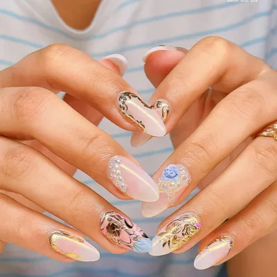 An example of my most detailed work, featuring 3D embellishments like pearls and a delicate blue rose on a base of gold foil and abstract art. This is wearable art for your fingertips.