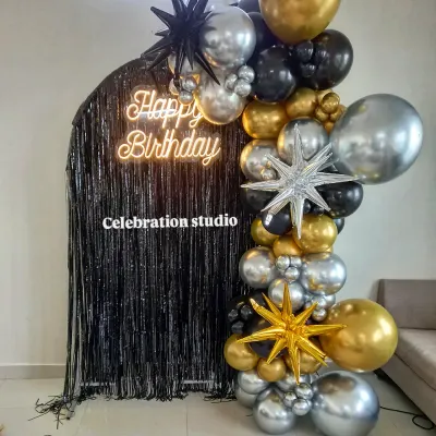For a truly modern and stylish birthday, I combined a black shimmer wall with a custom neon sign and a dramatic balloon arch in black, silver, and gold. This setup creates a perfect photo backdrop for any milestone celebration.
