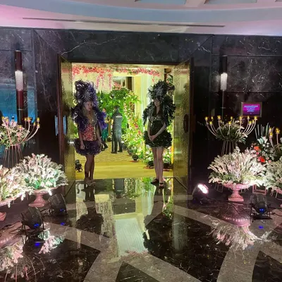 Performers in elaborate costumes greet guests at the entrance of a grand event. This is an example of how we incorporate entertainment and thematic elements right from the start to create an immersive and exciting arrival experience.