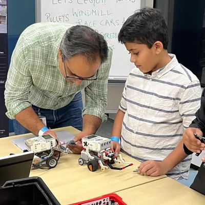 A father and son work together on a Sumo Bot challenge. We love seeing families get involved, with parents acting as mentors and coaches, fueling their child's curiosity and passion for technology.