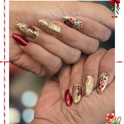 A bold and glamorous Christmas manicure. This set combines full-coverage gold glitter nails with rich red accents and hand-painted festive foliage for a truly celebratory look.