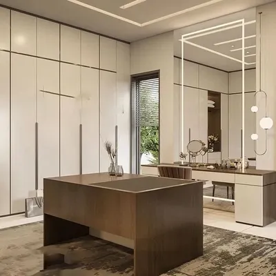A sophisticated walk-in closet and dressing room featuring floor-to-ceiling off-white wardrobes, a central island with drawers, and a dedicated vanity table with statement lighting. This design creates a luxurious and organized personal space.