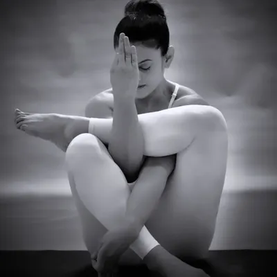 A moment of quiet contemplation in Garudasana, or Eagle Pose. This monochrome photo captures the internal focus and zen-like state that a dedicated yoga practice can bring.