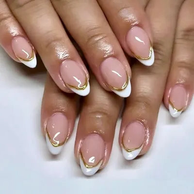 Soft glam with a golden edge. This is a beautiful example of a modern French, with a classic white tip elegantly separated from the nude base by a delicate, hand-painted gold line.