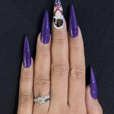 A full view of a custom character design on sculpted stiletto nails. The contrast between the solid, glossy purple and the detailed artwork on the accent nail makes this set a true statement piece.