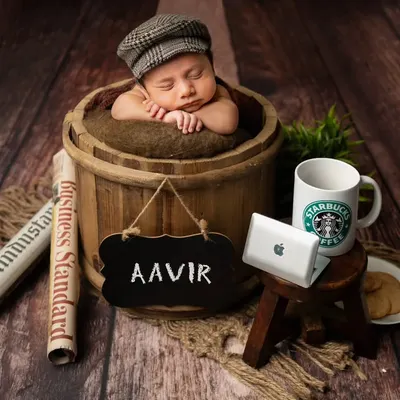 Meet the little boss! This fun, themed setup includes a mini laptop, a coffee mug, and a newspaper to create a playful "boss baby" portrait, perfect for a name reveal.