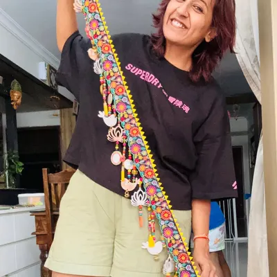Here I am, so happy holding up the finished 'Tamaara' toran. It’s a celebration of beauty and tradition, with lotus and bird artwork, soft tassels, and ghungroos that sing with every breeze.