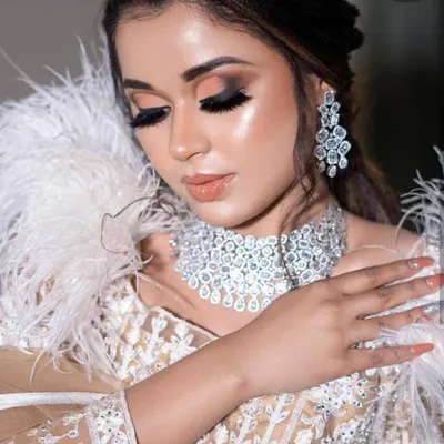 This glamorous ivory lehenga with feather details is the perfect rental for a cocktail party or reception. Pair it with our diamond-look jewellery to complete your show-stopping look.