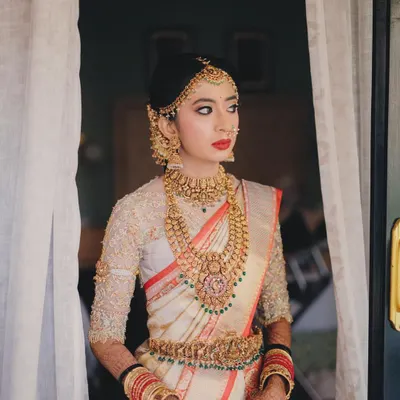 A picture of pure elegance. This bride's look features a classic red lip, a sharp wing, and a traditional matha patti, creating a timeless portrait for her wedding day.