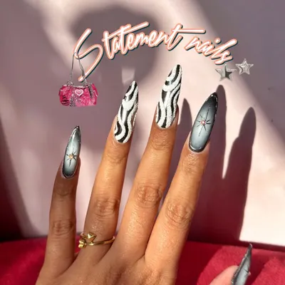 Statement nails featuring a bold zebra print and airbrushed star accents. This is for when you want to stand out.