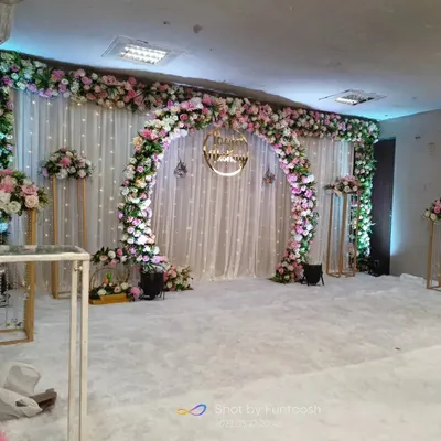 A wide view of our pink and white floral arch setup for a sakharpuda. The white carpet and matching floral stands create a complete, cohesive look for the main stage area.