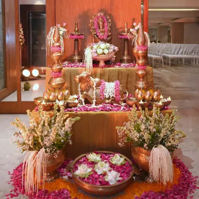 A complete Ganpati puja setup I designed. It features a central altar with the idol, flanked by traditional brass lamps and vessels, a Nandi statue, and an abundance of fresh flowers and petals, creating a truly divine space.