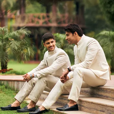 The groom's tribe in coordinated ivory and paisley Jodhpuri suits. This candid shot captures the camaraderie and style of the groomsmen, perfectly dressed for a summer wedding.