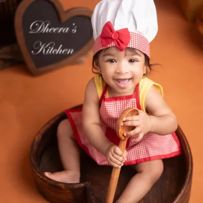 Welcome to the 'Little Chef' kitchen! This is such a fun theme for a sitter milestone or half-birthday shoot. This baby girl's cheeky smile and playful pose with the wooden spoon say it all.