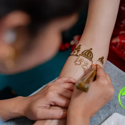 A close-up of the application process. Here, I am carefully drawing the domes of a palace motif on the bride's forearm, ensuring every line is perfect.