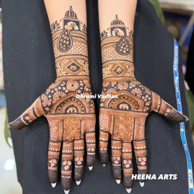 A classic Indian bridal mehendi featuring elegant peacocks and elephant motifs. The contrast between the delicate line work and the bold, filled-in elements makes the design pop.