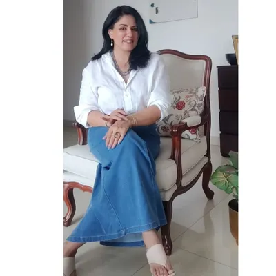 A seated pose in my classic white linen shirt and denim skirt, a perfect outfit for celebrating a 30-year friendship.