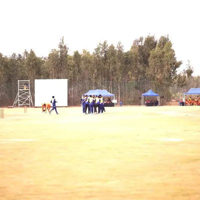A wide shot of the Indian Corporate Cricket League, showcasing the full event setup with multiple pitches, player tents, and spectator areas, all managed by our team.